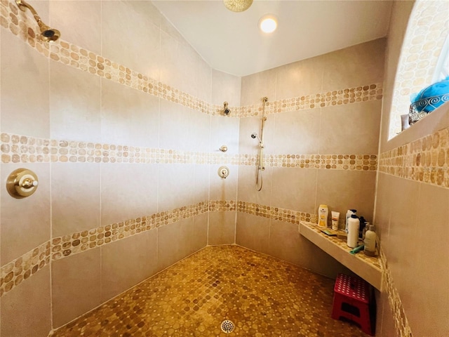 bathroom featuring a tile shower and tile walls