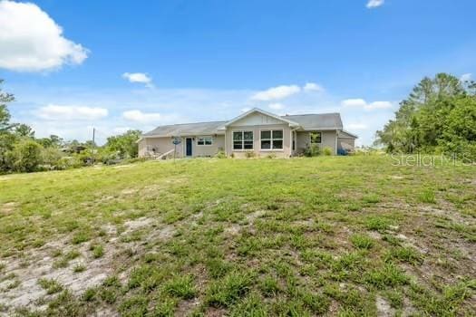 7941 Sycamore Dr, New Port Richey, FL 34654 - rear view of property with a yard