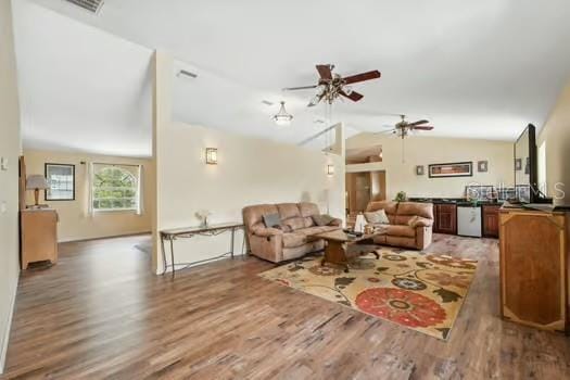 7941 Sycamore Dr, New Port Richey, FL 34654 - living room featuring vaulted ceiling, wood finished floors, and a ceiling fan