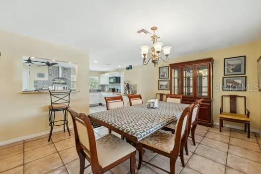 7941 Sycamore Dr, New Port Richey, FL 34654 - dining room with a chandelier, light tile patterned floors, and a ceiling fan