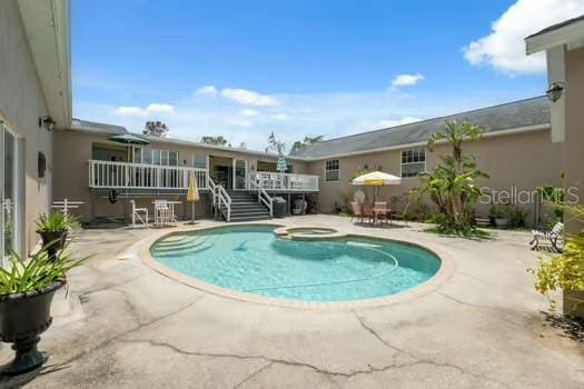 7941 Sycamore Dr, New Port Richey, FL 34654 - swimming pool with a patio area, a wooden deck, stairway, and an in-ground hot tub