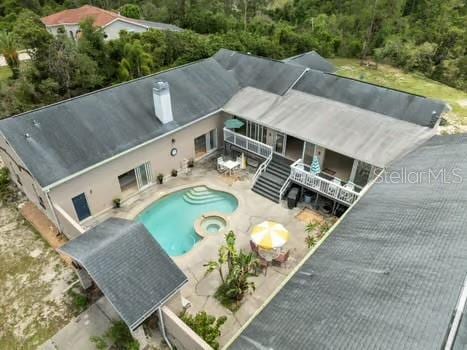 7941 Sycamore Dr, New Port Richey, FL 34654 - view of swimming pool with a patio area, a pool with connected hot tub, and a forest view