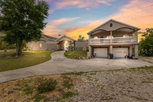 7941 Sycamore Dr, New Port Richey, FL 34654 - view of front of home featuring driveway, a balcony, an attached garage, and a front yard