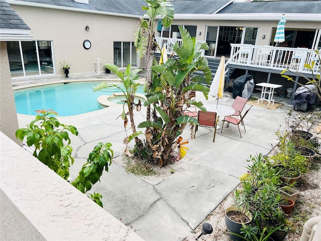 7941 Sycamore Dr, New Port Richey, FL 34654 - view of swimming pool featuring a patio, a deck, outdoor dining space, a pool with connected hot tub, and grilling area