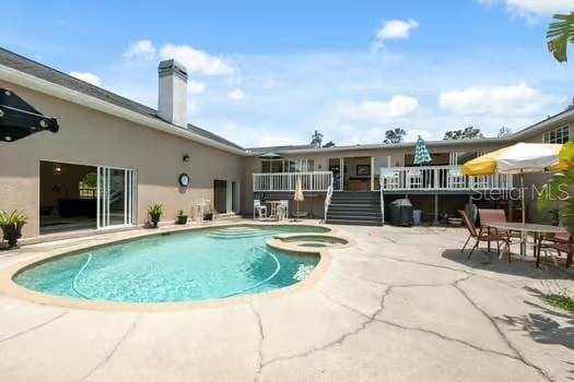 7941 Sycamore Dr, New Port Richey, FL 34654 - view of pool with a patio area, a wooden deck, and a pool with connected hot tub