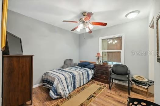 7941 Sycamore Dr, New Port Richey, FL 34654 - bedroom with wood finished floors and ceiling fan