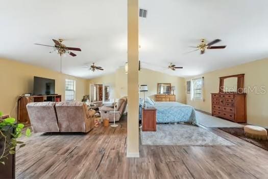 7941 Sycamore Dr, New Port Richey, FL 34654 - bedroom with vaulted ceiling and wood finished floors