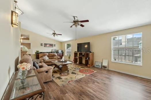 7941 Sycamore Dr, New Port Richey, FL 34654 - living area with wood finished floors, a ceiling fan, and lofted ceiling