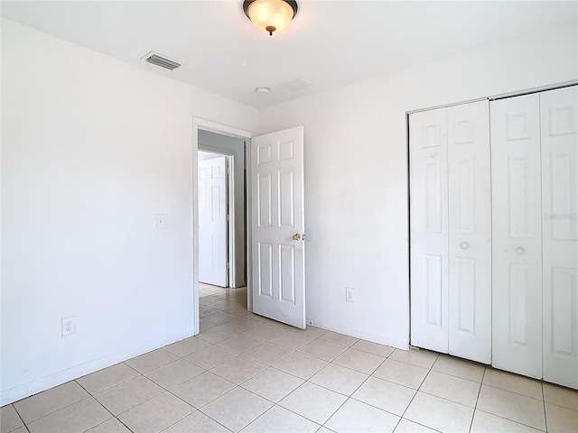 unfurnished bedroom with light tile patterned floors and a closet