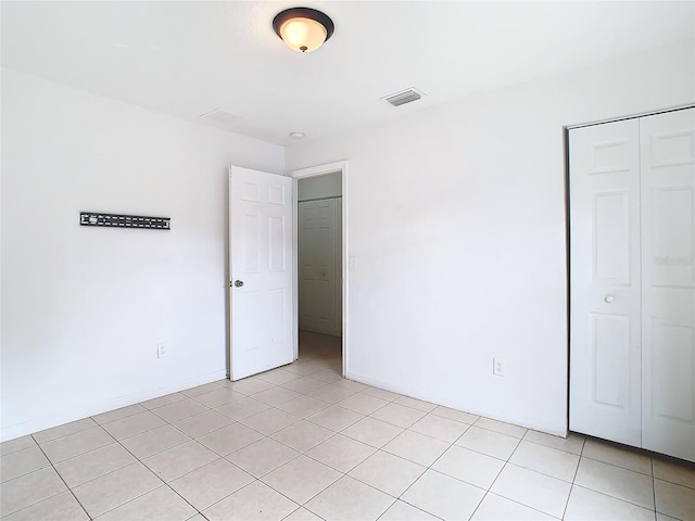 unfurnished bedroom featuring a closet and light tile patterned flooring