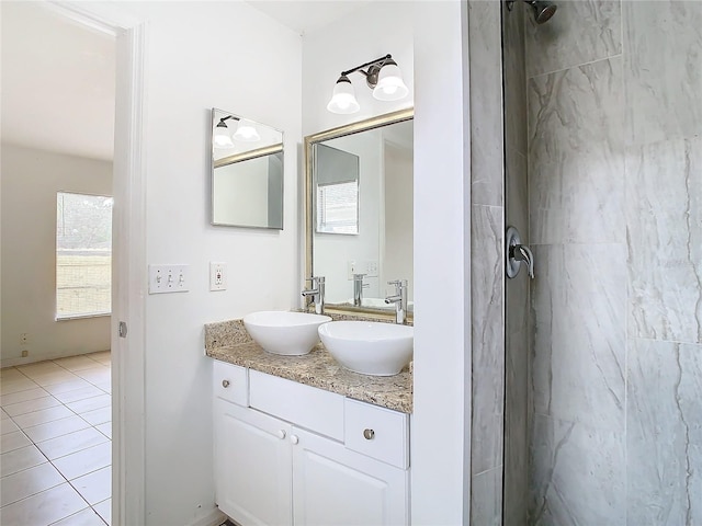 bathroom featuring a tile shower, tile patterned flooring, and vanity