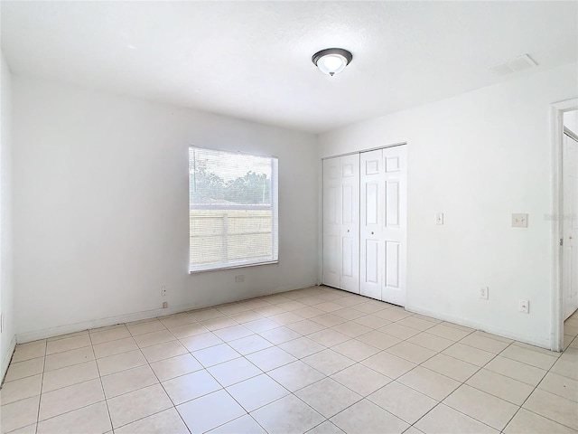 unfurnished bedroom with light tile patterned floors and a closet