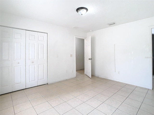 unfurnished bedroom featuring light tile patterned floors and a closet