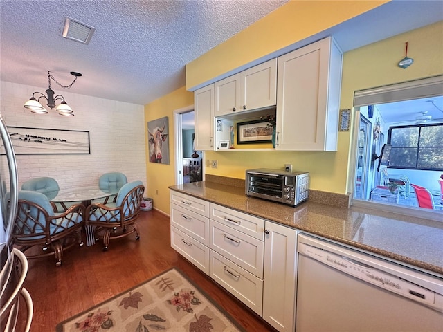 kitchen with white dishwasher, white cabinets, decorative light fixtures, dark hardwood / wood-style flooring, and a chandelier