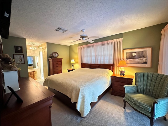 bedroom with carpet flooring, a textured ceiling, ensuite bath, and ceiling fan