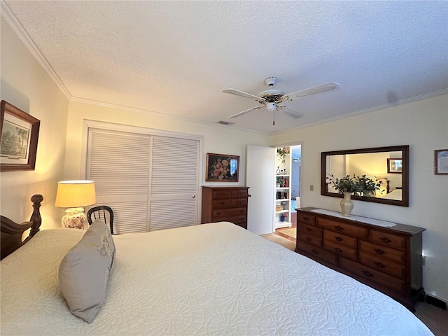 bedroom with ceiling fan, crown molding, a textured ceiling, and a closet