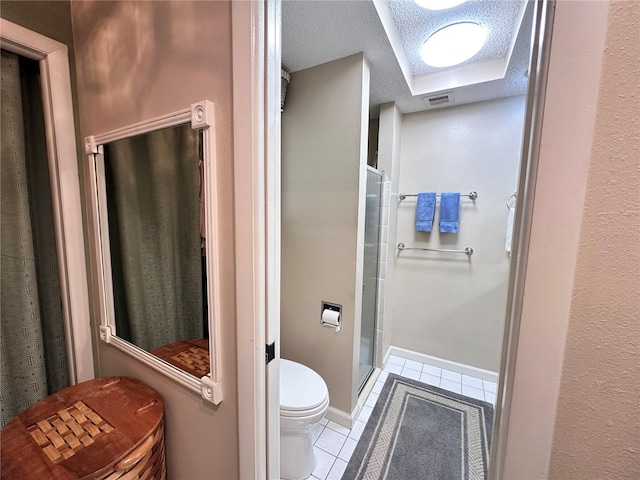 bathroom with tile patterned flooring, a textured ceiling, and toilet