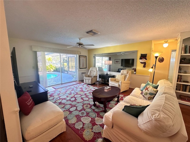 living room with wood-type flooring, plenty of natural light, and ceiling fan