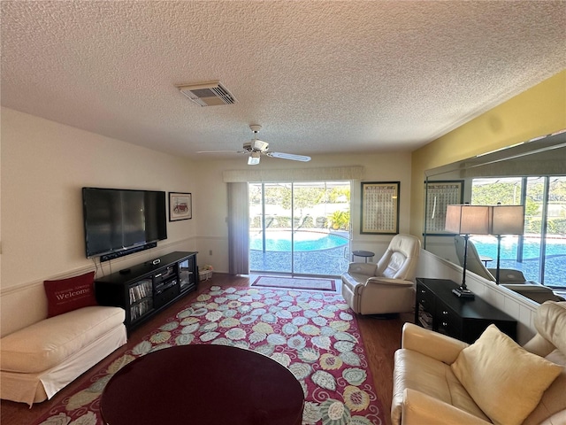 living room with hardwood / wood-style floors, a textured ceiling, and ceiling fan