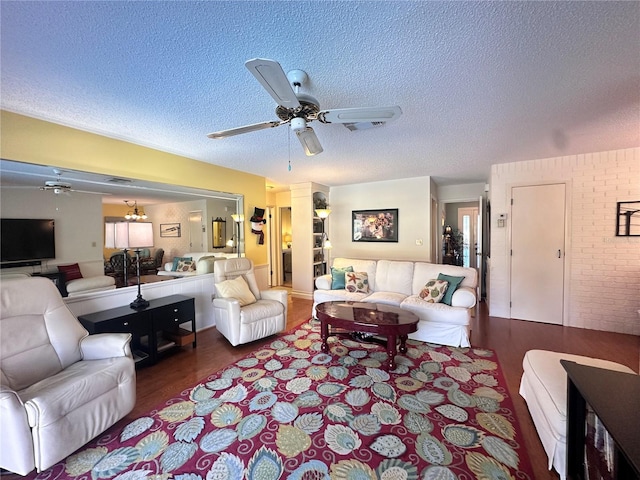 living room featuring a textured ceiling, ceiling fan, and dark wood-type flooring