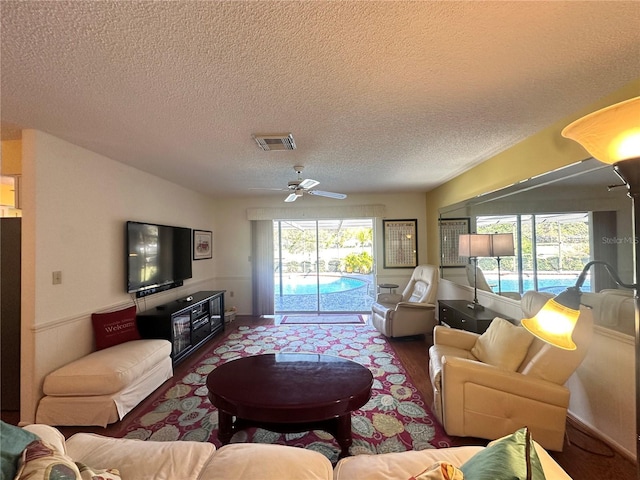 living room featuring hardwood / wood-style floors, ceiling fan, a textured ceiling, and a wealth of natural light