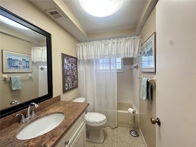 full bathroom with vanity, shower / bath combo, tile patterned floors, toilet, and a textured ceiling