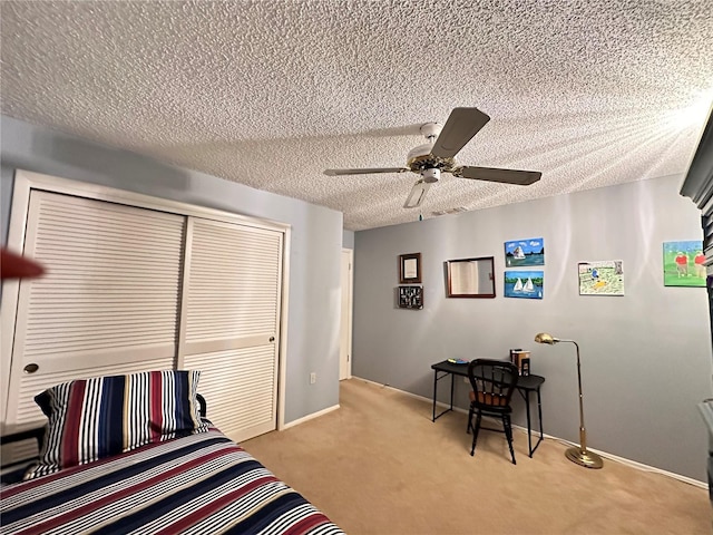 carpeted bedroom featuring ceiling fan, a textured ceiling, and a closet