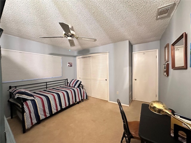 carpeted bedroom featuring ceiling fan and a textured ceiling