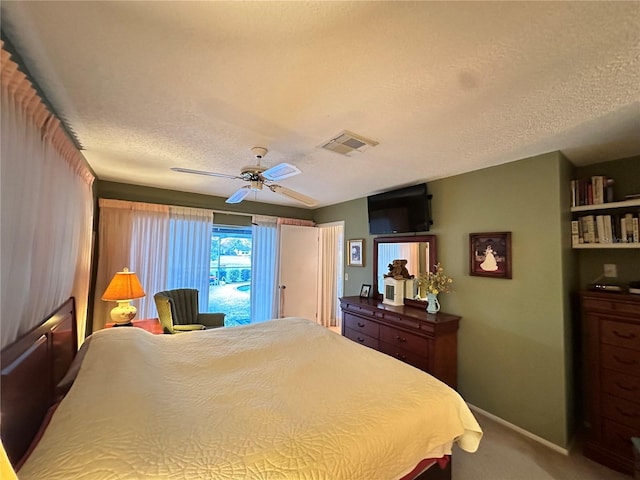 carpeted bedroom with ceiling fan and a textured ceiling