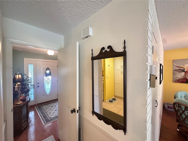 foyer with a textured ceiling and dark wood-type flooring