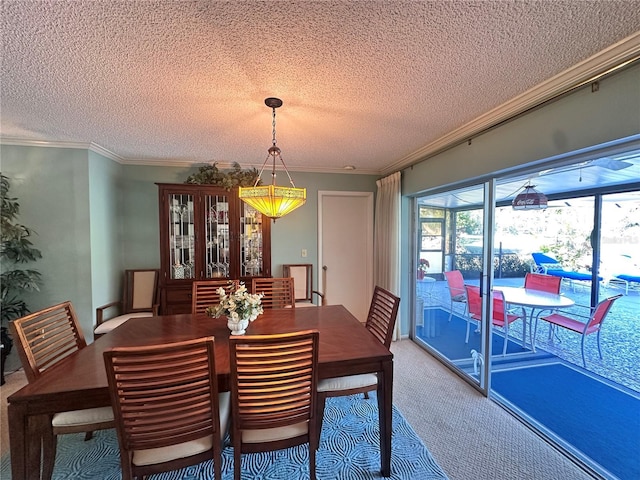 carpeted dining room with a textured ceiling and ornamental molding