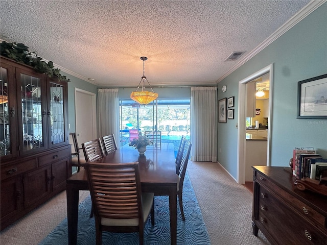 carpeted dining space with a textured ceiling and ornamental molding