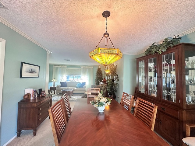 carpeted dining room with a textured ceiling and ornamental molding