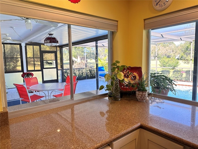 doorway to outside featuring ceiling fan and plenty of natural light