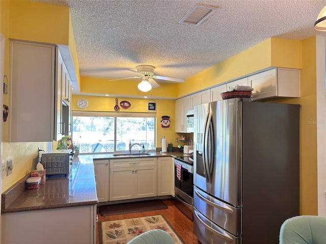 kitchen featuring white cabinets, sink, ceiling fan, appliances with stainless steel finishes, and dark hardwood / wood-style flooring