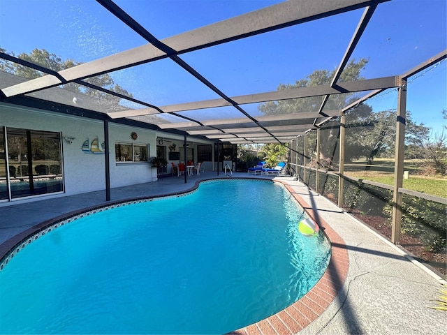 view of swimming pool featuring a patio and a lanai