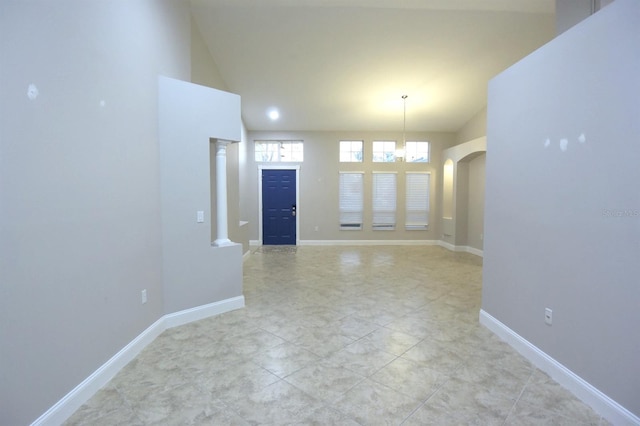 unfurnished room with vaulted ceiling and an inviting chandelier