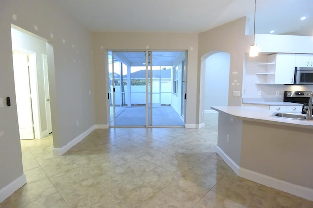 kitchen featuring light tile patterned flooring, appliances with stainless steel finishes, white cabinetry, and sink