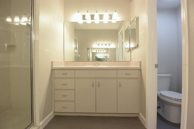 bathroom featuring an enclosed shower, vanity, and toilet