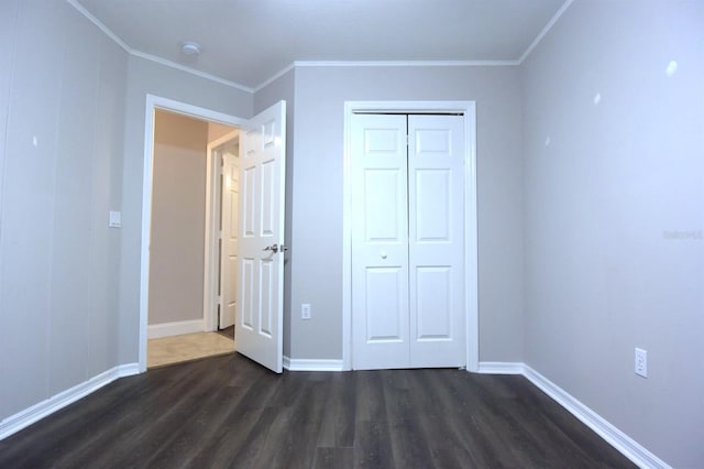 unfurnished bedroom with dark hardwood / wood-style floors, a closet, and ornamental molding