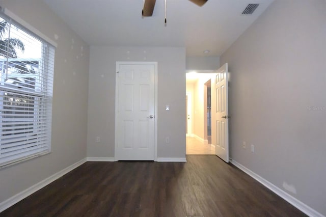 unfurnished bedroom with ceiling fan and dark hardwood / wood-style floors