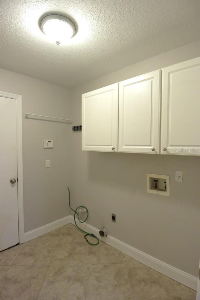 washroom with electric dryer hookup, cabinets, a textured ceiling, and hookup for a washing machine