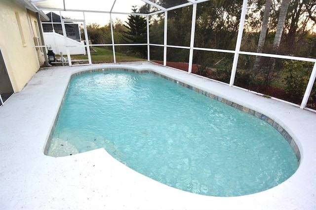 view of swimming pool featuring glass enclosure