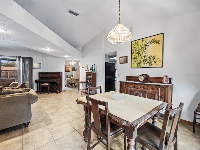 tiled dining space with a chandelier, a textured ceiling, and lofted ceiling