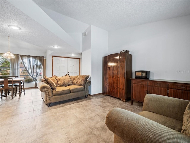 living room with vaulted ceiling, light tile patterned floors, and a textured ceiling