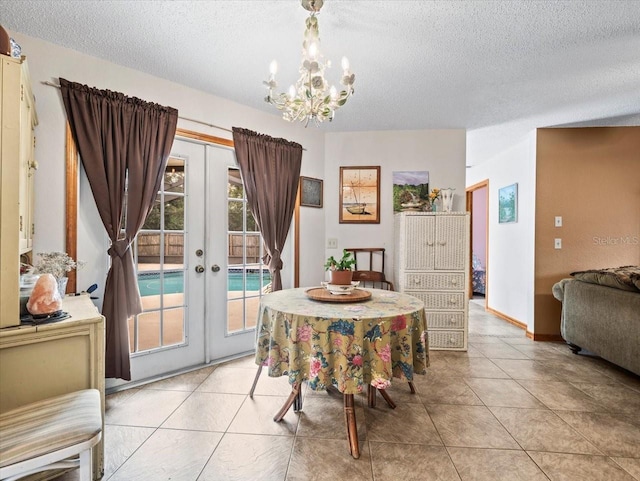 dining space featuring a chandelier, light tile patterned flooring, a textured ceiling, and french doors