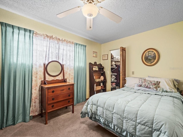 bedroom featuring carpet, a textured ceiling, a closet, and ceiling fan