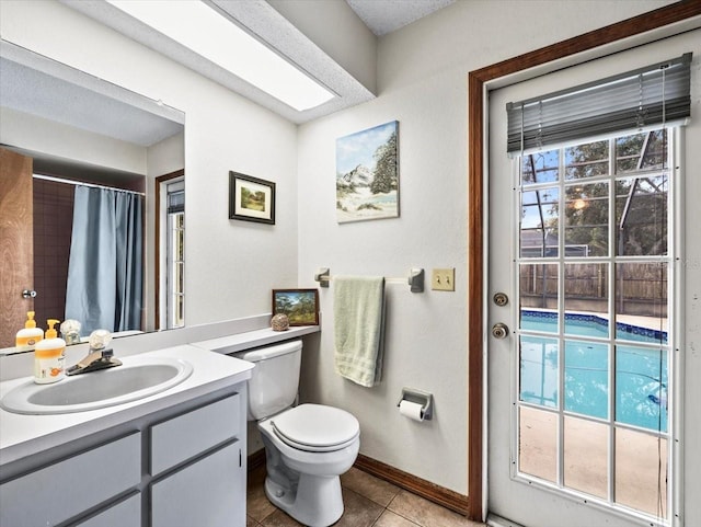 bathroom with walk in shower, a textured ceiling, vanity, tile patterned flooring, and toilet