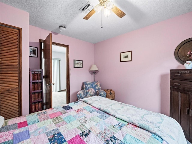 bedroom featuring a textured ceiling, a closet, and ceiling fan