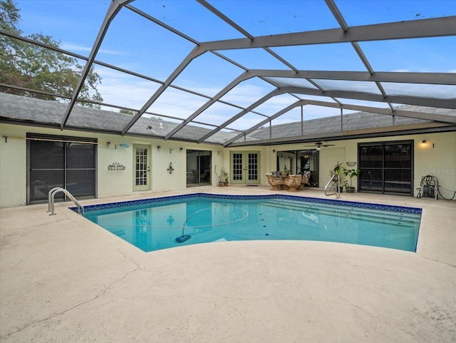 view of swimming pool featuring french doors, a patio area, ceiling fan, and a lanai